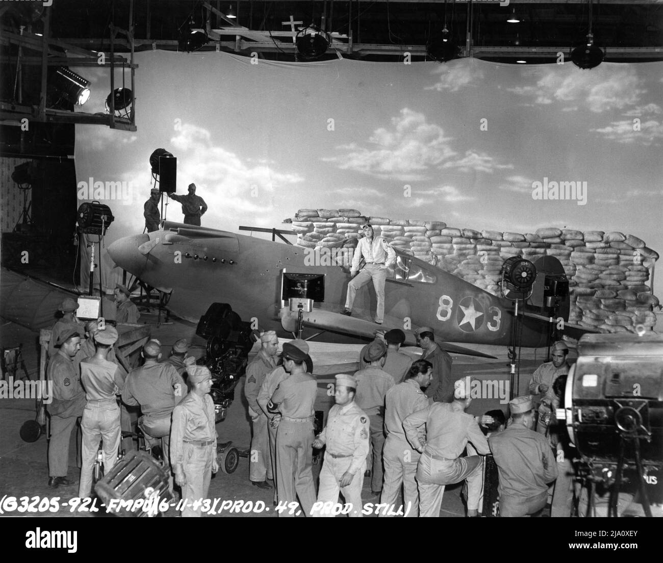 Military Movie Crew on Set Candid Filming a Pilot with His Curtiss P-40 Warhawk Single Engine Fighter Plane on Hollywood Studio Sound Stage il 11th giugno 1943 per un US Army Air Corps / US Army Air Force (USAAF) Propaganda Film Foto Stock
