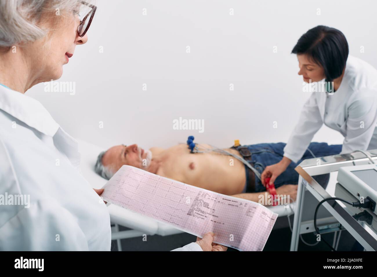 Test del cardiogramma, primo piano del referto ECG su pazienti maschi anziani. Diagnosi e trattamento dell'attacco di cuore Foto Stock