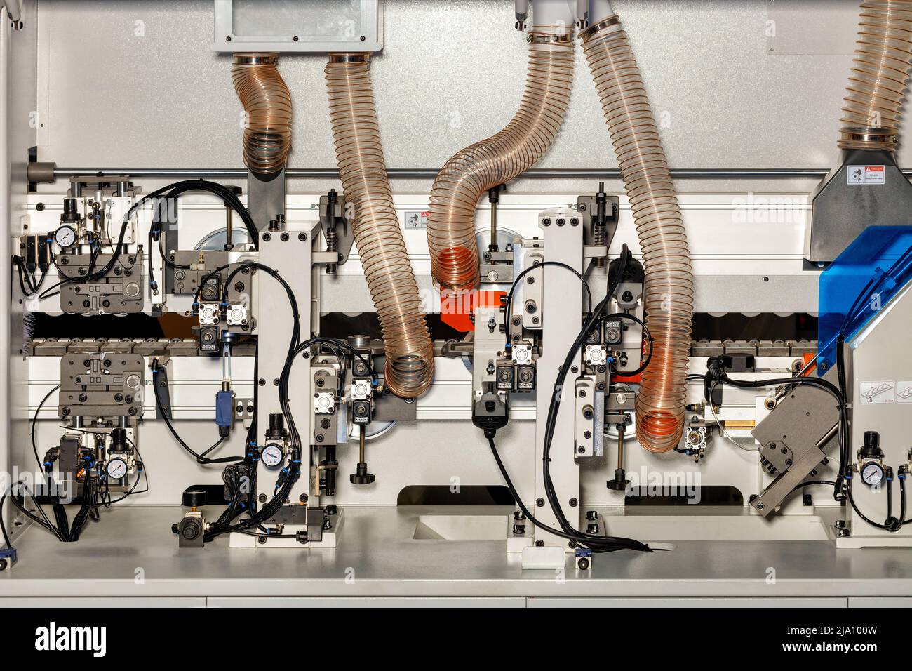 Un frammento dei meccanismi di controllo interno dell'impianto pneumatico in una moderna macchina per la lavorazione del legno con manometri e meccanismi di controllo. Foto Stock
