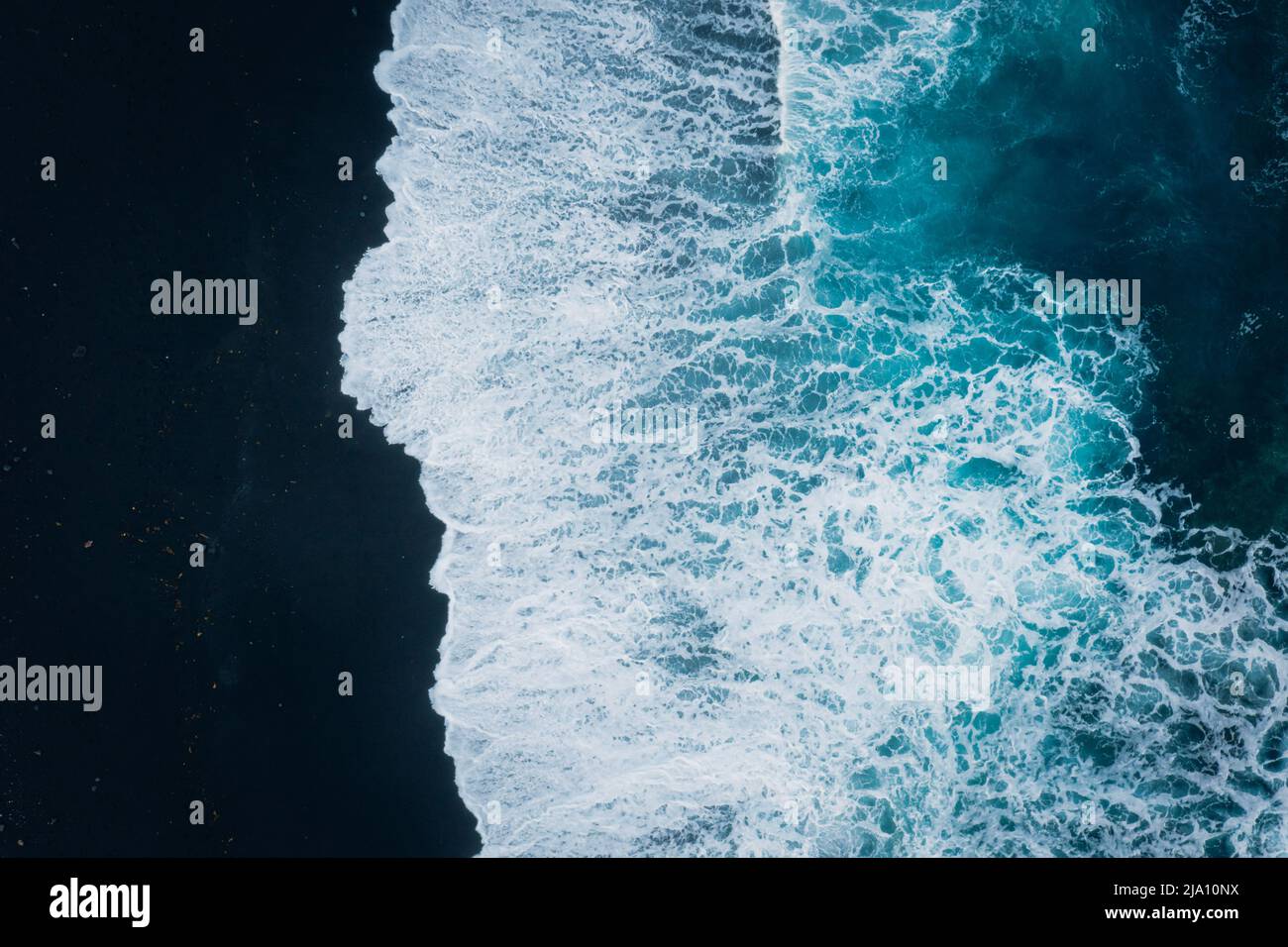 Blaues Meer und schwarzer Strand Foto Stock
