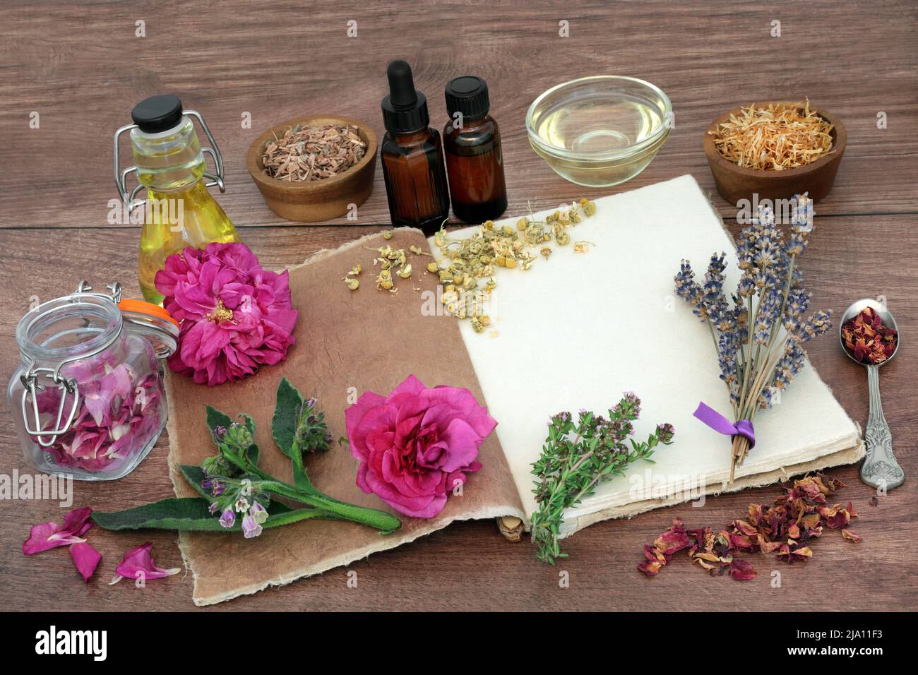 Aromaterapia preparazione essenziale per la cura della pelle trattamenti con erbe e fiori per il trattamento di eczema, psoriasi, acne con vecchio notebook di canapa. Foto Stock