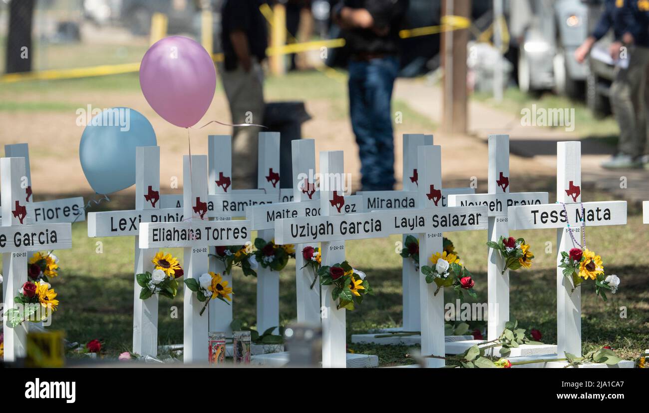 Uvalde, Texas USA, 26th maggio, 2022. Attraversa con il nome di ogni linea di vittima il marciapiede di fronte alla scuola elementare Robb a Uvalde, mentre la gente continua a portare i fiori sulla scena del martedì di ripresa di massa. Un gunman entrò a scuola e uccise 19 bambini e due insegnanti. Credit: Bob Daemmrich/Alamy Live News Foto Stock