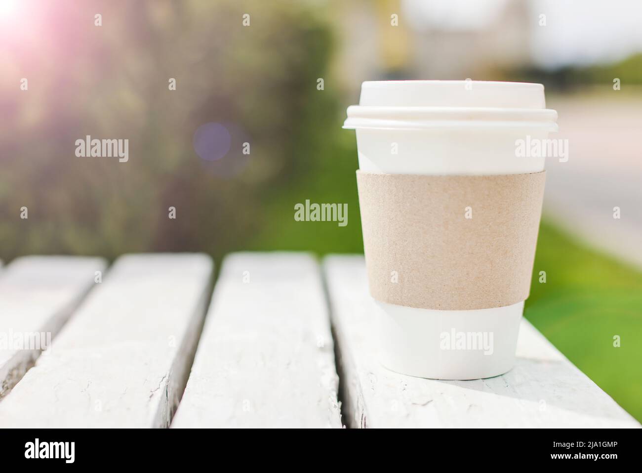 Mockup di take away usa e getta contenitore di carta da caffè o tazza su strada. Minimal, ecologia, stile di vita concetto. Fuoco selettivo copia spazio Foto Stock