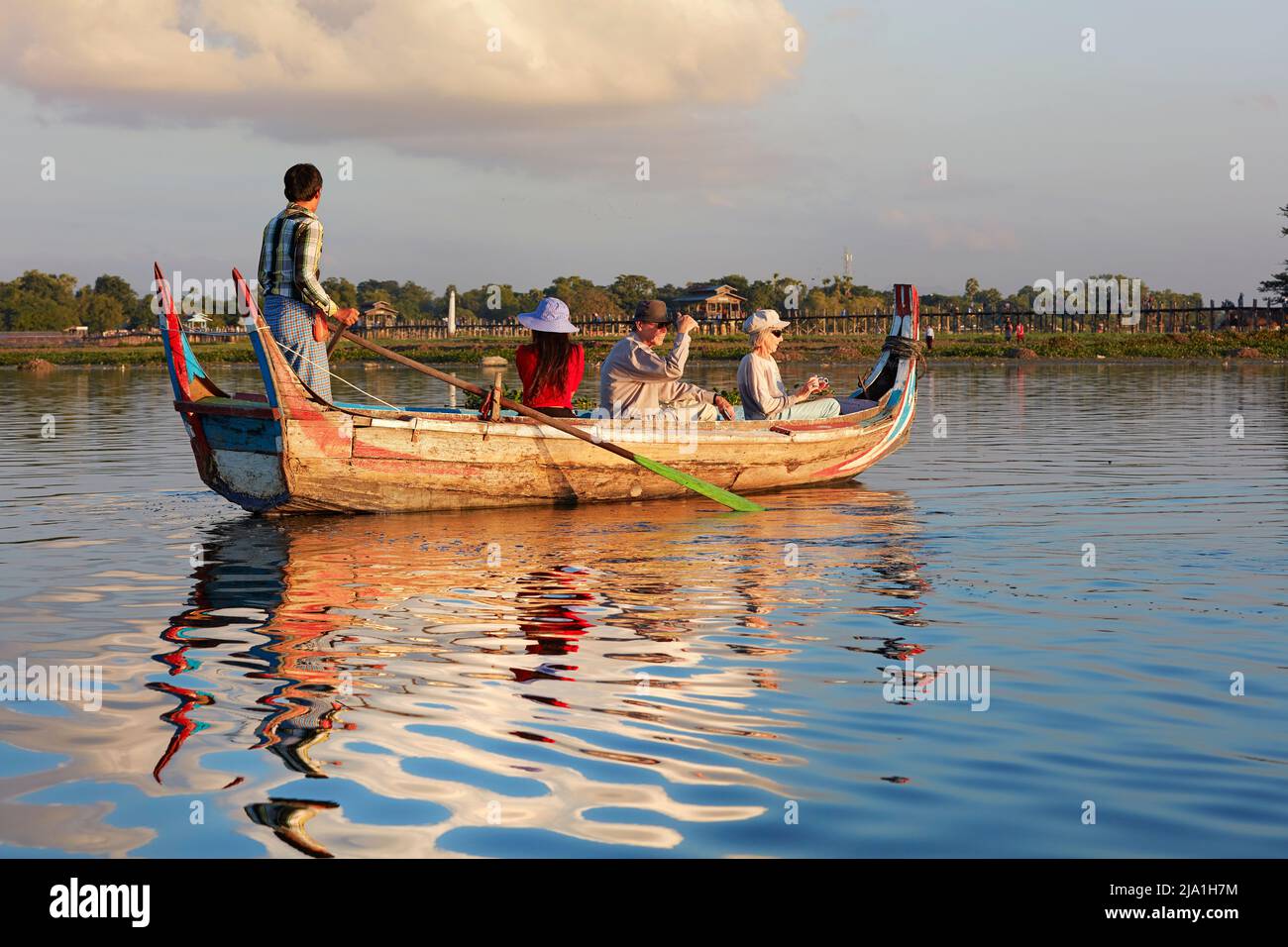 I turisti che guardano il tramonto nel ponte U-Bein su una tradizionale barca di legno, Amarapura, Mandalay, Myanmar. Foto Stock