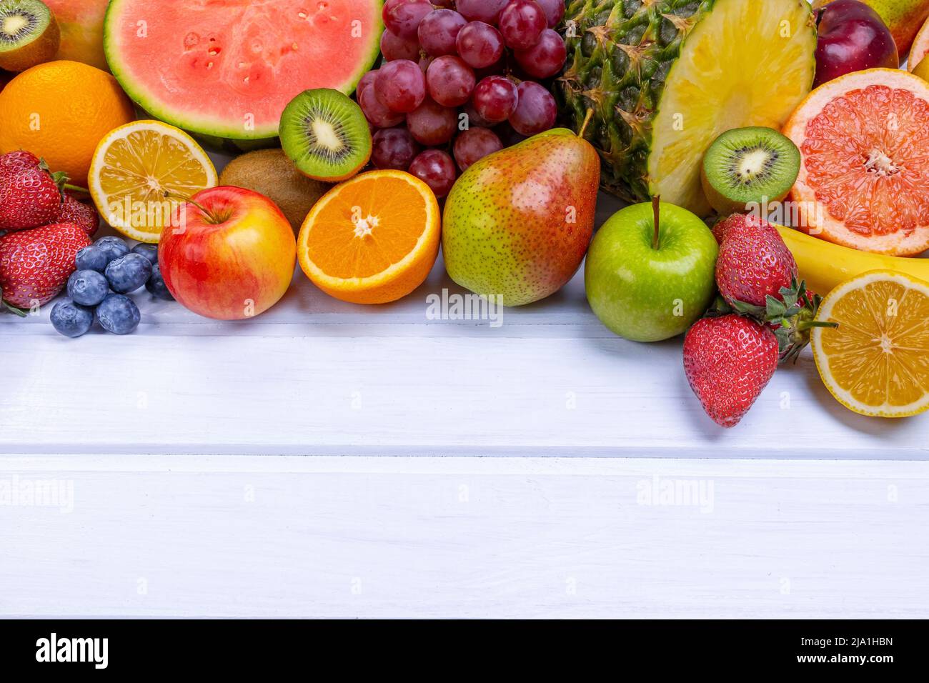 Frutta fresca assortita per un'alimentazione sana. Cocomero, ananas, mela, pera, fragola, kiwi, limone, arancia, uva, mirtillo, melograno, mango, b Foto Stock