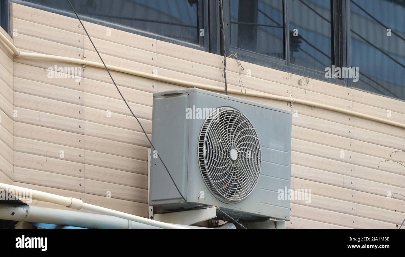 Compressore dell'unità di condizionamento dell'aria o unità condensante installata all'esterno della parete dell'edificio. Concetto che mostra l'apparecchiatura per ufficio e casa Foto Stock