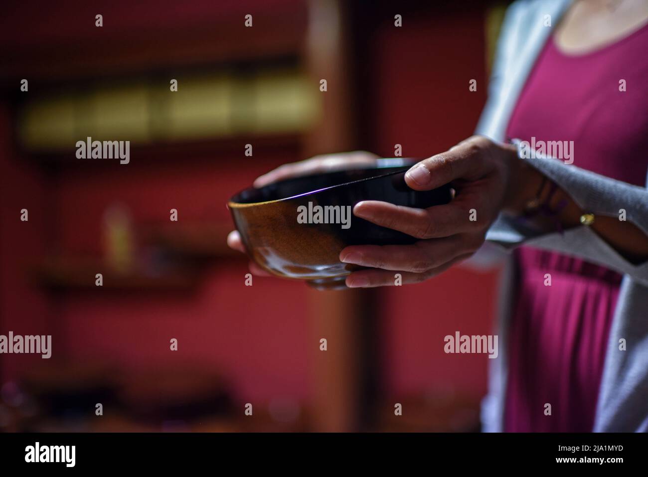 Giovane donna che tiene una ciotola giapponese fatta a mano Foto Stock