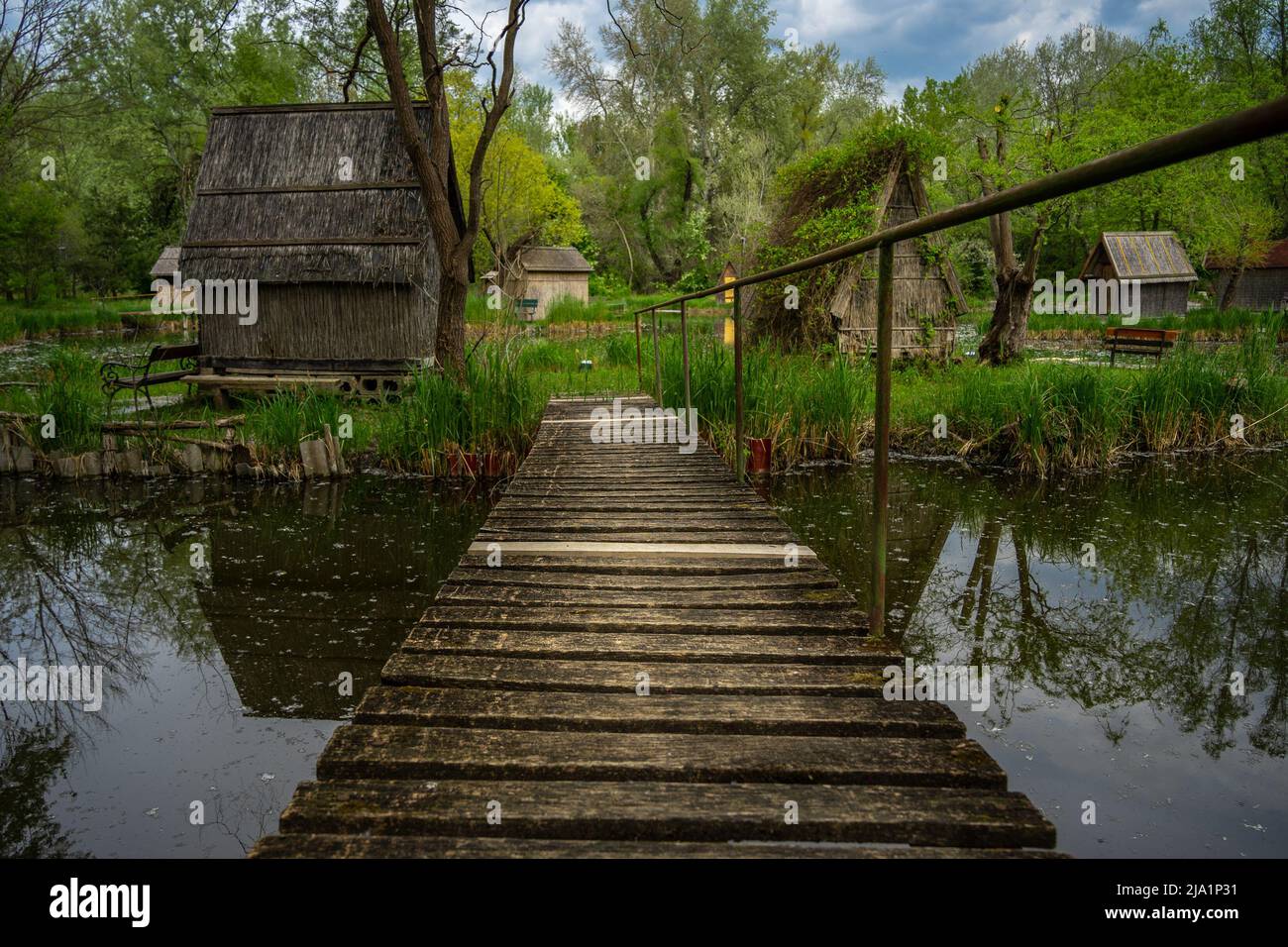 Ponte di accesso in legno alle piccole case del lago di pesca a Sződliget, Ungheria Foto Stock