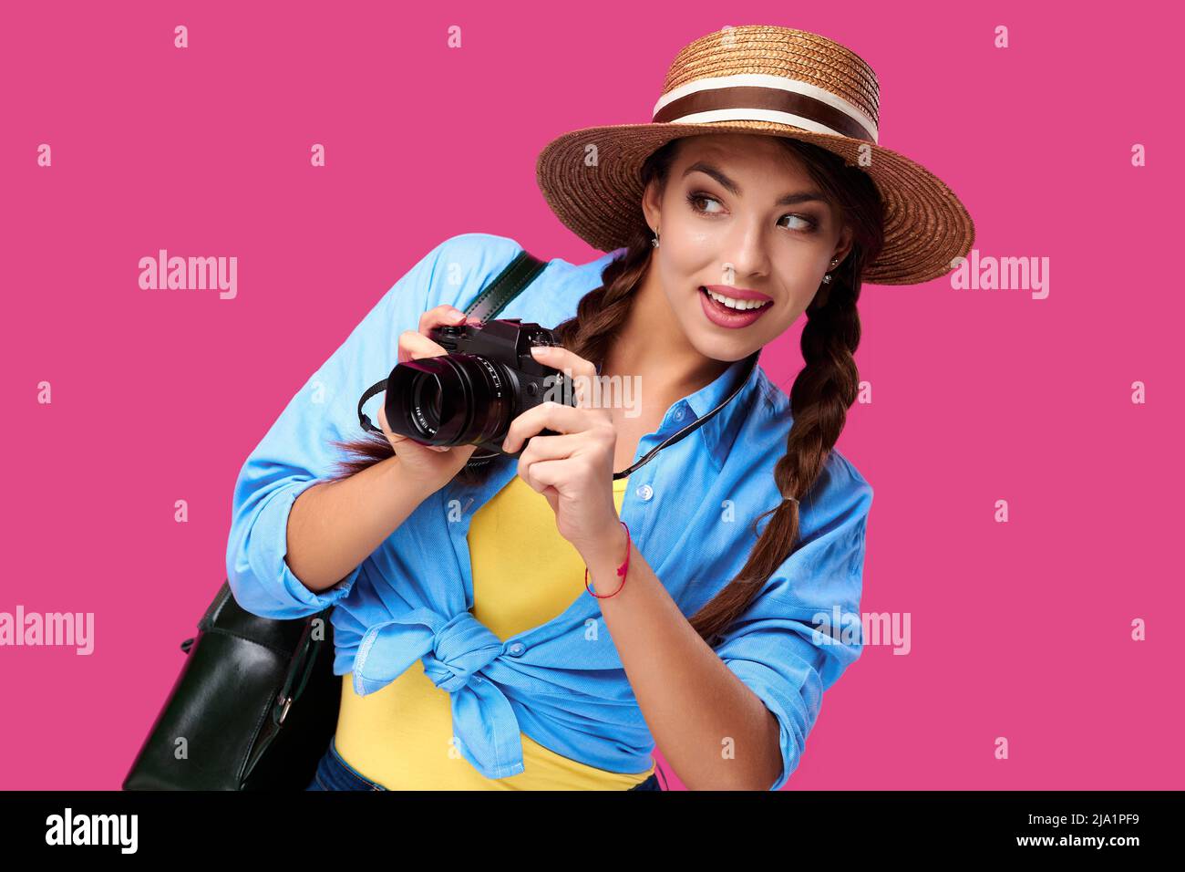 Concetto di turismo. Felice donna caucasica turista in estate abbigliamento casual con fotocamera, isolato su sfondo rosa con spazio copia Foto Stock