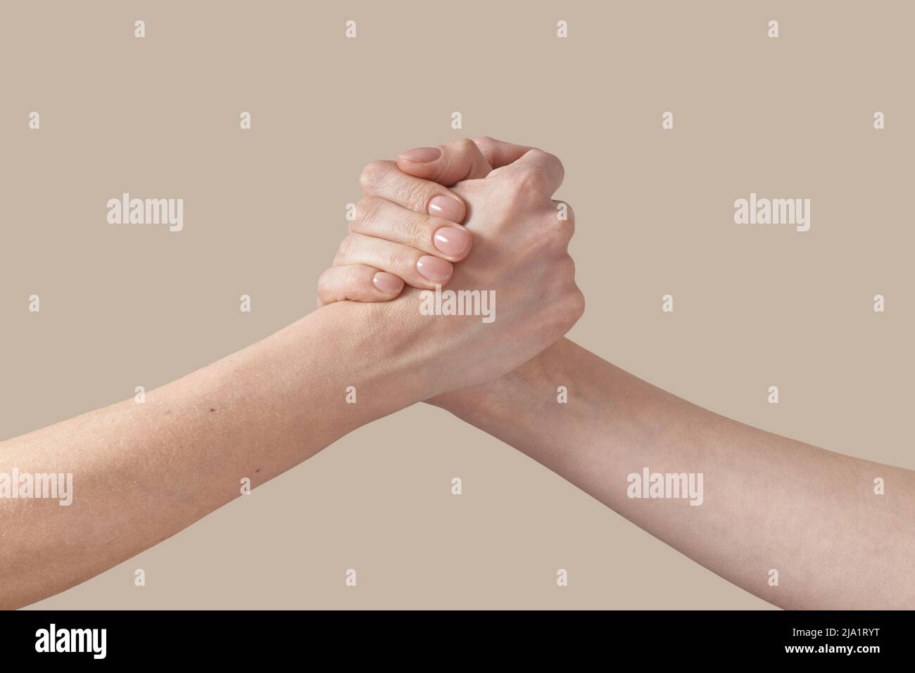Due uomini e donne stringono la mano sul beige. Foto Stock