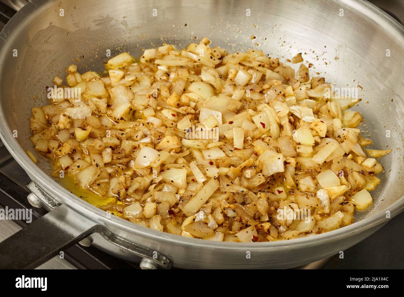 Cipolle caramellate in una padella d'acciaio Foto Stock