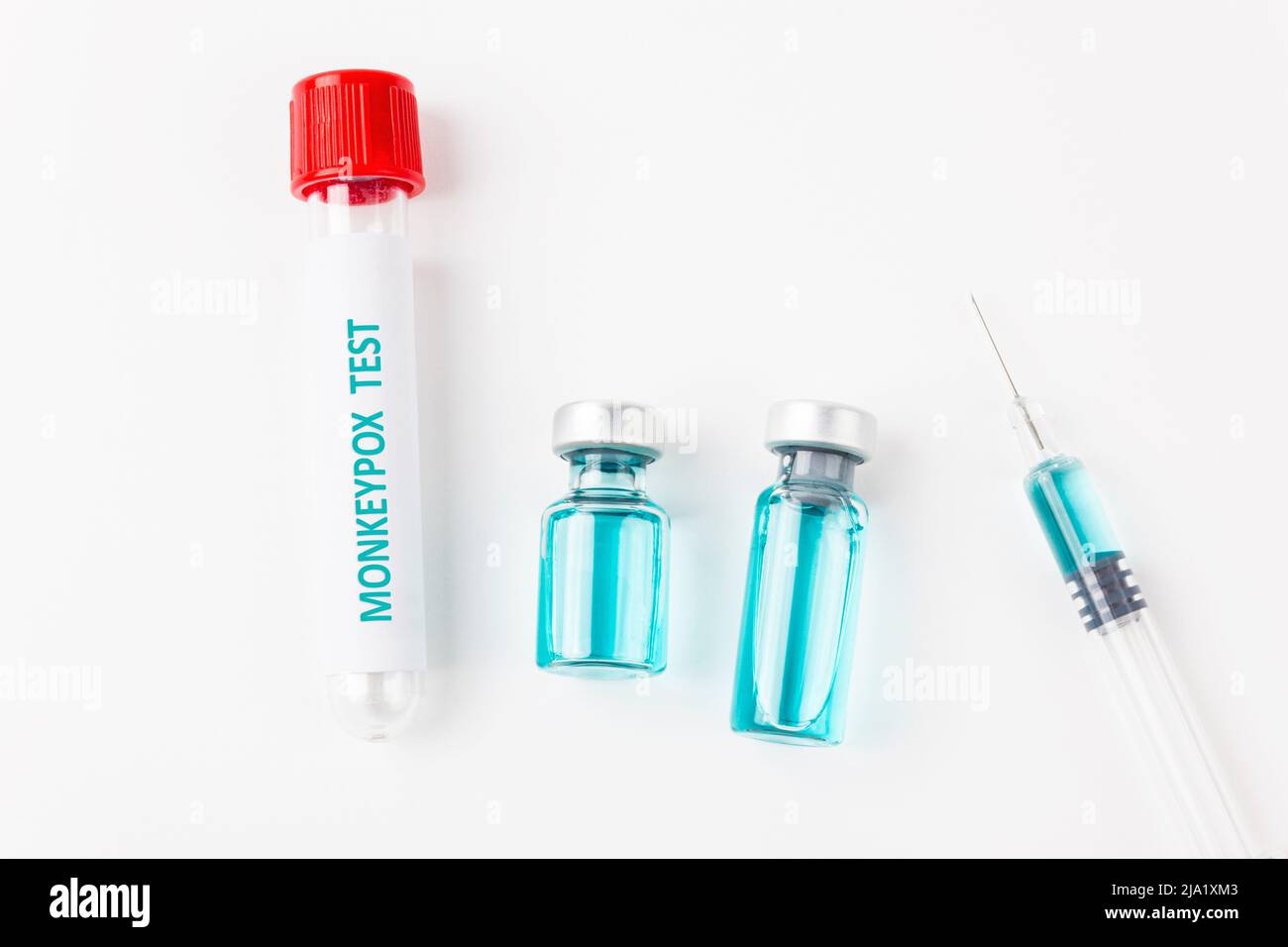 Provetta per il campione di sangue per il test del virus Monkeypox e siringa con varicella vaccinale su sfondo bianco. Concetto medico. Vista dall'alto. Foto Stock
