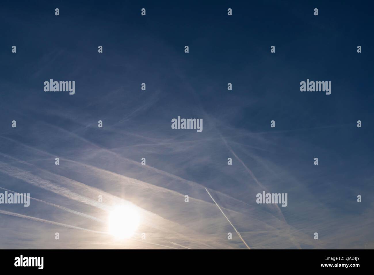 Sole con piste di condensazione nel cielo del pomeriggio, Baviera, Germania Foto Stock