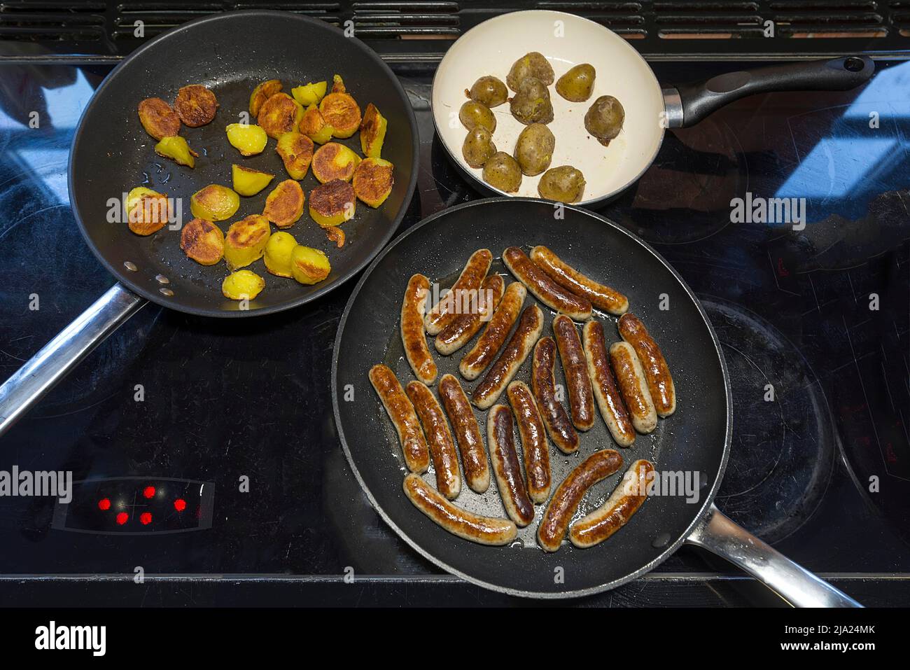 Salsicce di Norimberga, patate fritte in padelle sul fornello, Baviera, Germania Foto Stock