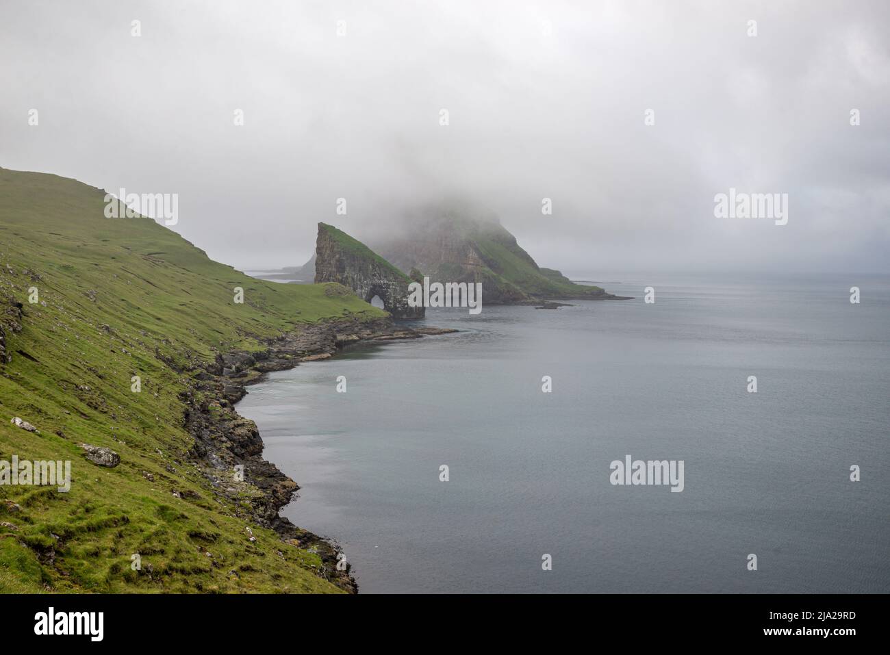 La roccia di Drangarnir nella nebbia, Vagar, Isole Faroe Foto Stock