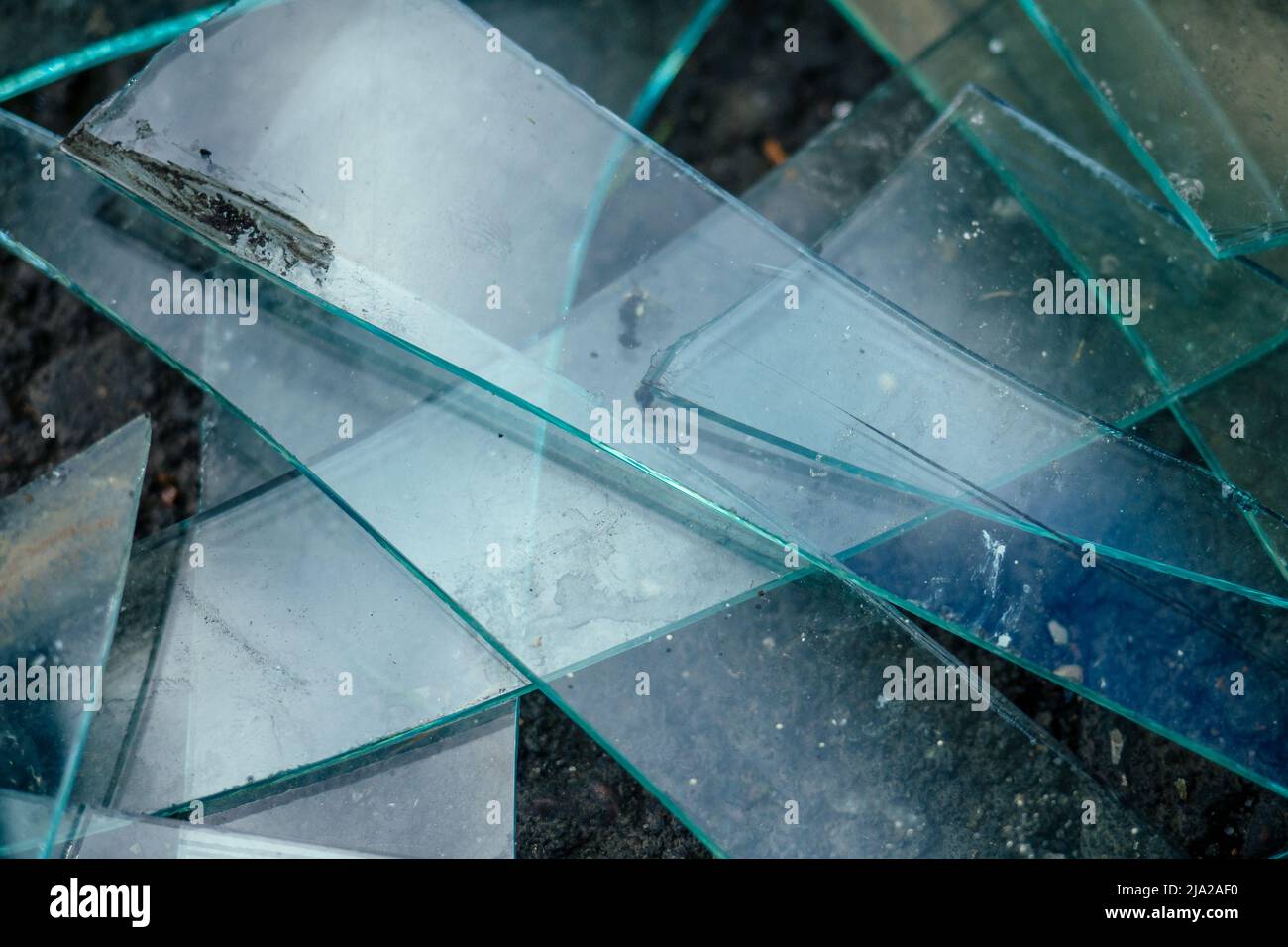 una piccola pila di vetro rotto giacente sull'asfalto Foto Stock