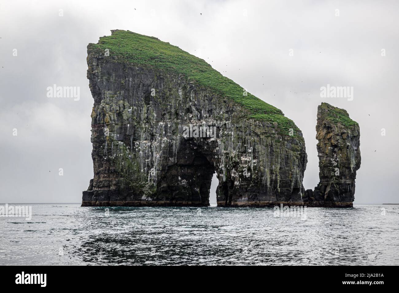 La formazione rocciosa di Drangarnir fatta da due pile di mare viste da una barca, Vagar, Isole Faroe Foto Stock