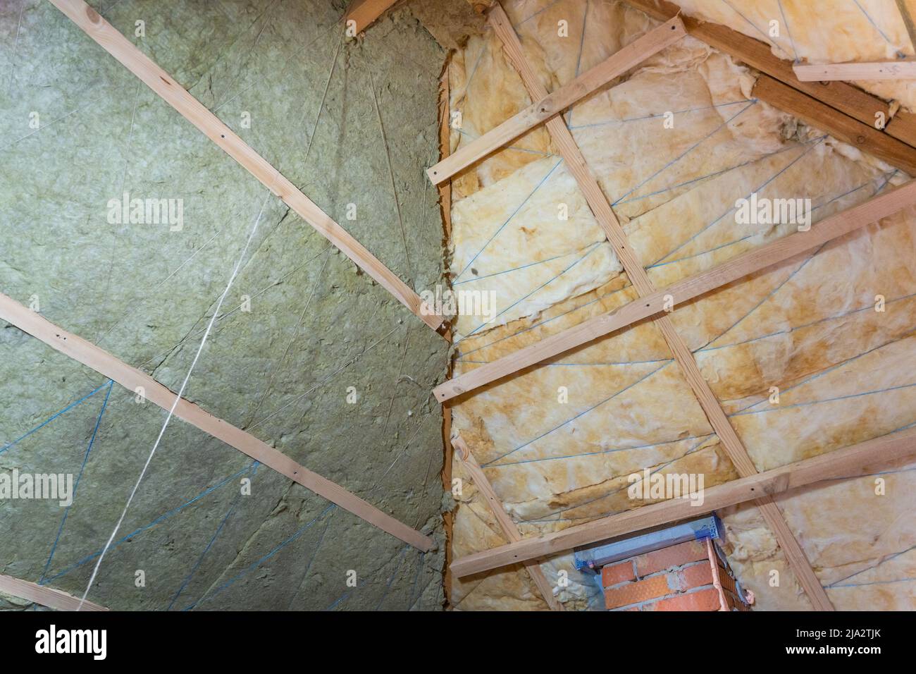 Il processo di isolamento del tetto con lana di vetro e lana minerale Foto Stock
