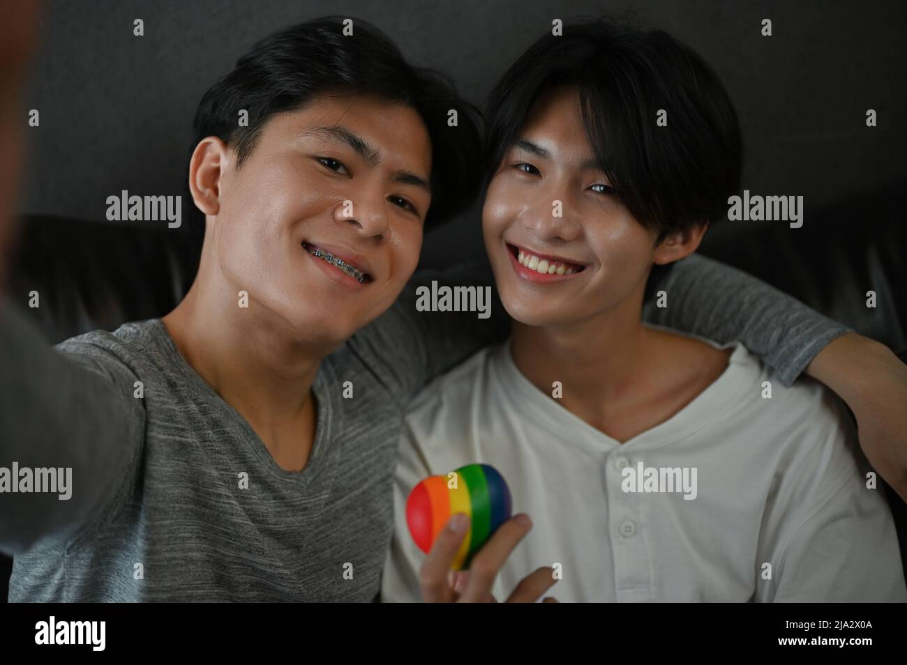 Ritratto di una coppia asiatica teen gay che tiene un cuore arcobaleno. LGBT orgoglio amore simbolo. Concetto omosessuale. Foto Stock
