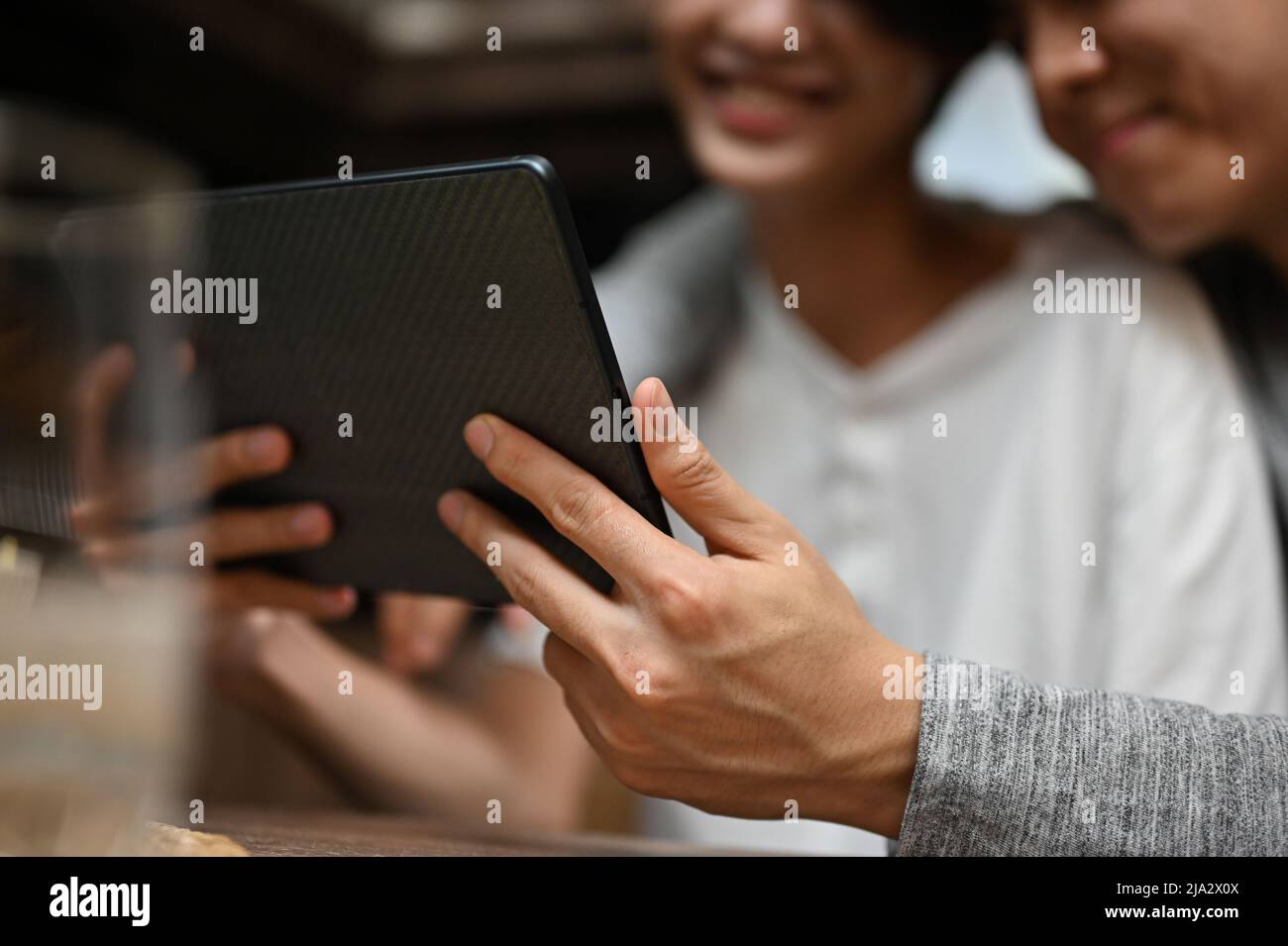 Immagine ravvicinata, le coppie gay Teenage si divertiranno a guardare un film insieme su un tablet digitale a casa. Concetto di coppie LGBT Foto Stock