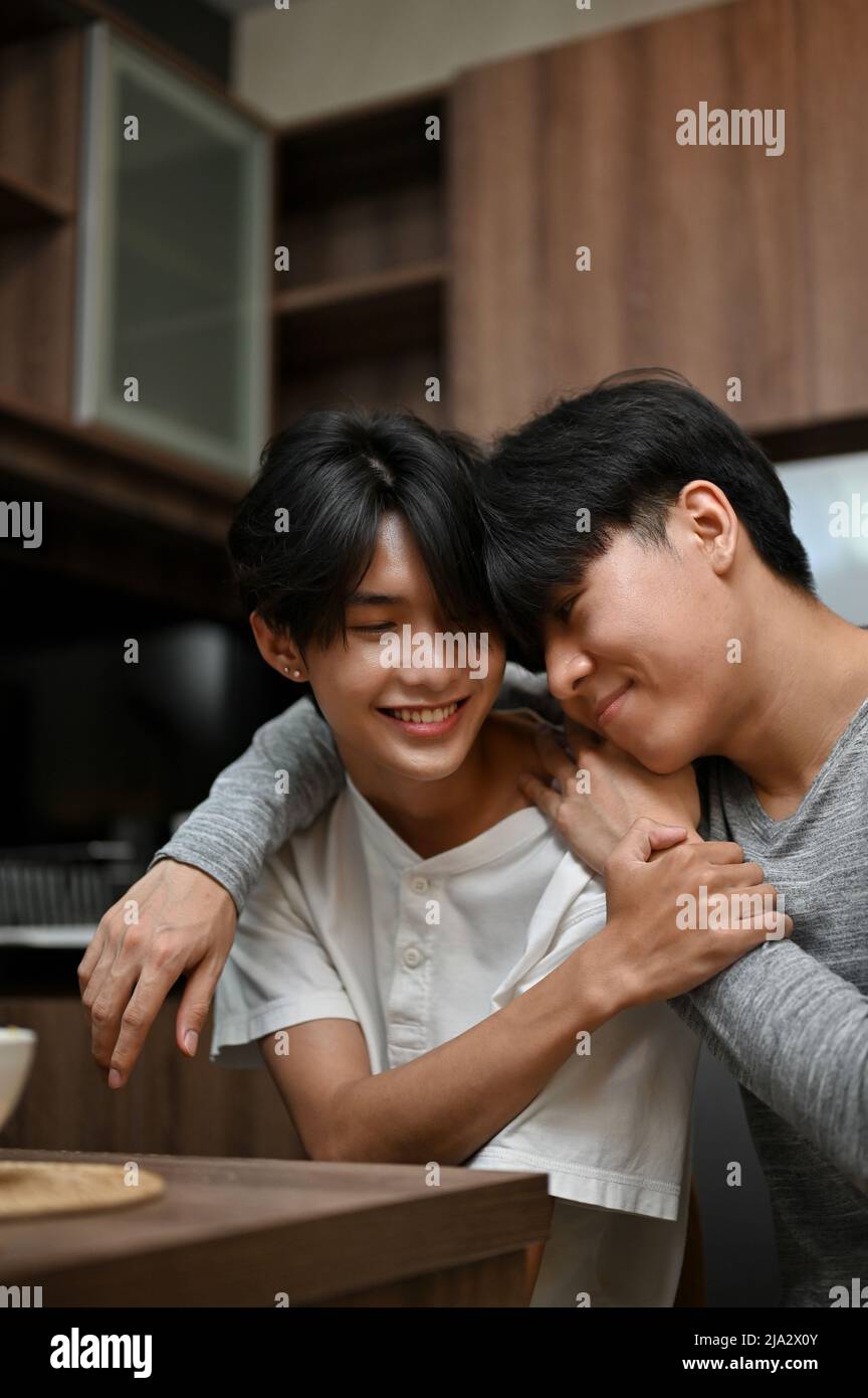 Ritratto di un giovane asiatico abbracciando o coccolando il suo amante gay, mano intorno al suo amante con romantica sensazione di amore. LGBT amore affetto. Foto Stock