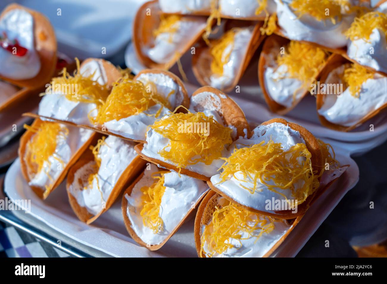 Deliziosa strada Thai dessert, Kanom Buang, Tailandese frittelle croccanti o Thai crêpe con varietà di farciture come bianco e dolce crema pasticcera e golden Foto Stock