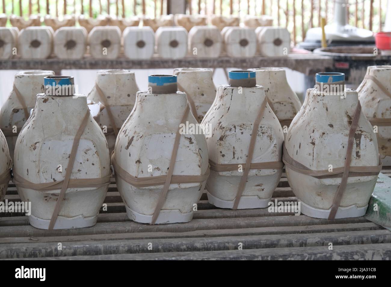 Gli stampi per la realizzazione dei vasi sono disposti su scaffale in attesa della formazione del terreno. Processo di fabbricazione di un vaso di ceramica. Artigianato e concetto di piccola impresa. Foto Stock