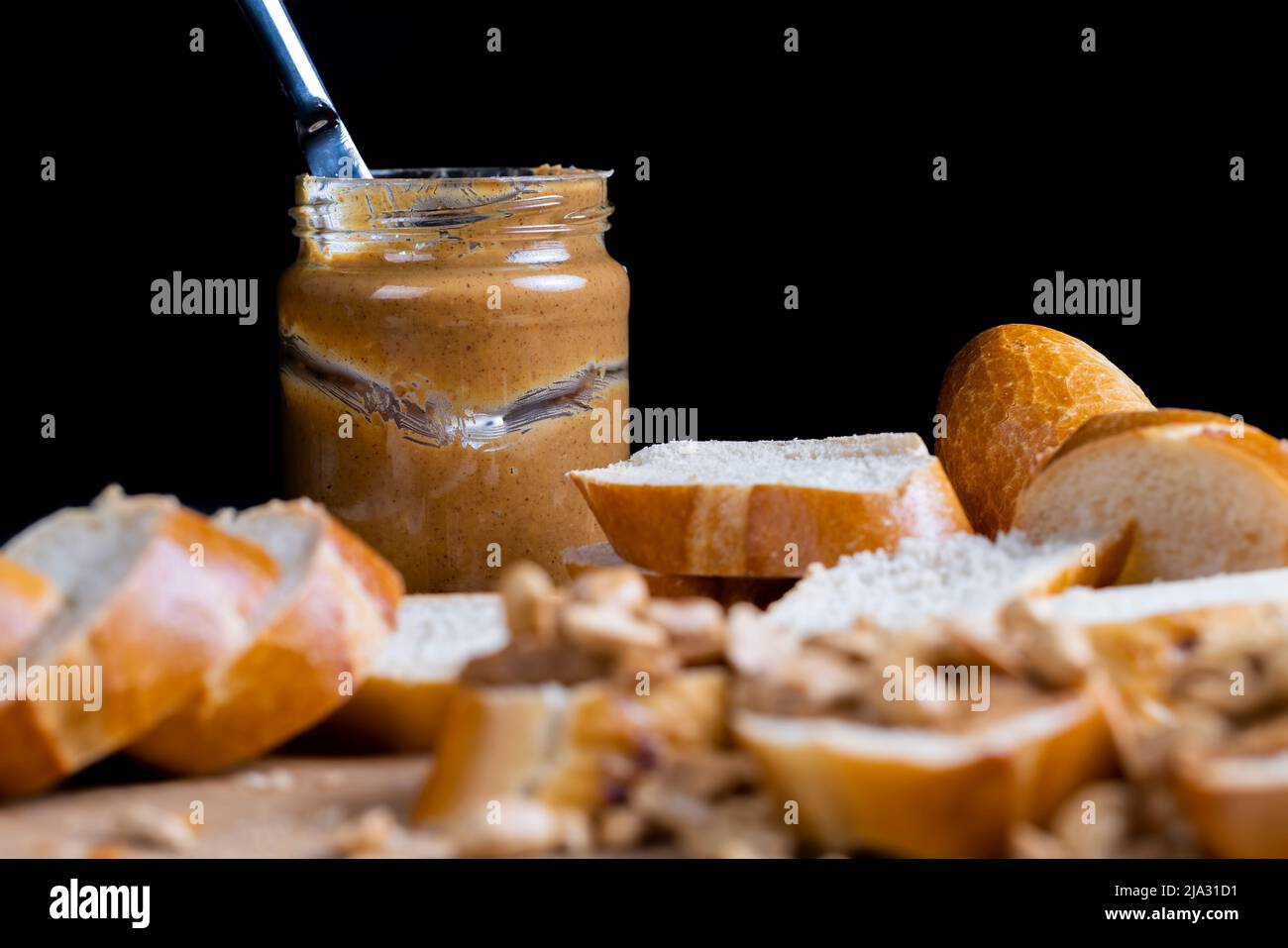baguette di grano fresco e pasta di arachidi, facendo colazione di pane e burro di arachidi con pezzi di arachidi Foto Stock
