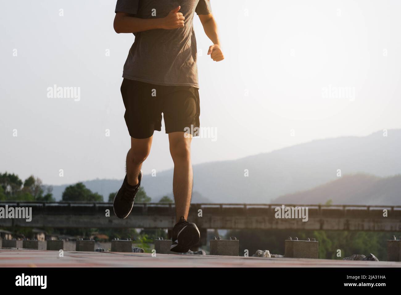 I piedi del corridore del giovane uomo che corrono sulla strada stanno correndo per l'esercitazione. Concetto sano di esercitazione. Foto Stock