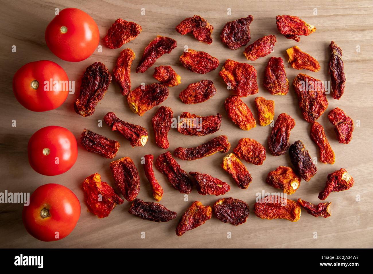 Pomodori freschi e pomodori secchi con fondo in legno Foto Stock
