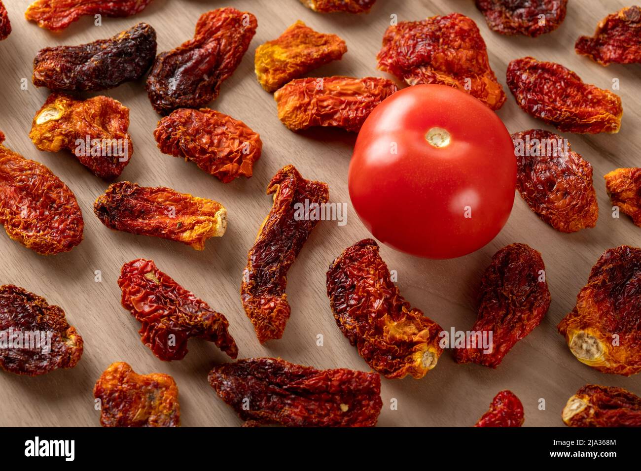 Pomodori freschi e pomodori secchi con fondo in legno Foto Stock