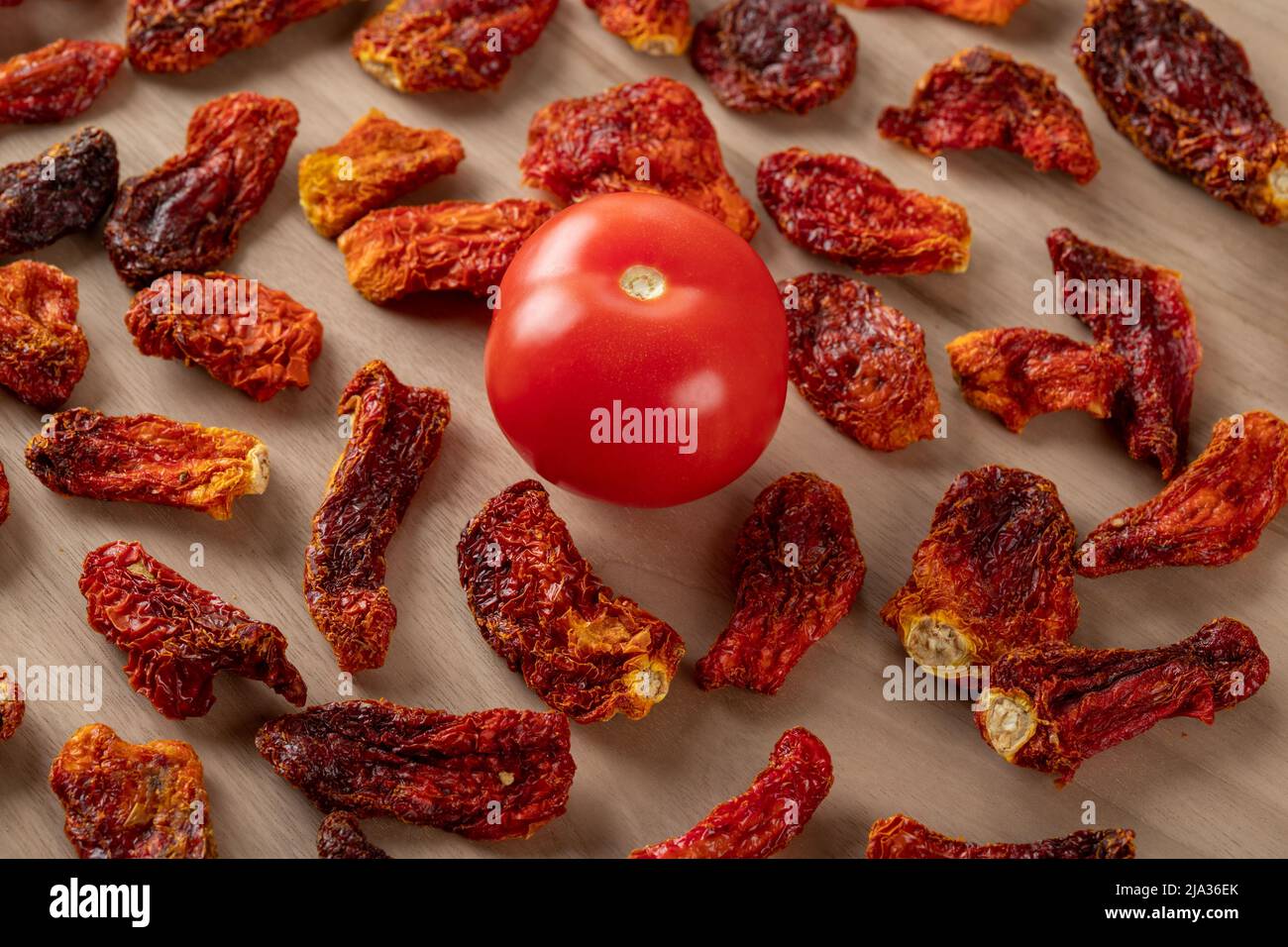 Pomodori freschi e pomodori secchi con fondo in legno Foto Stock