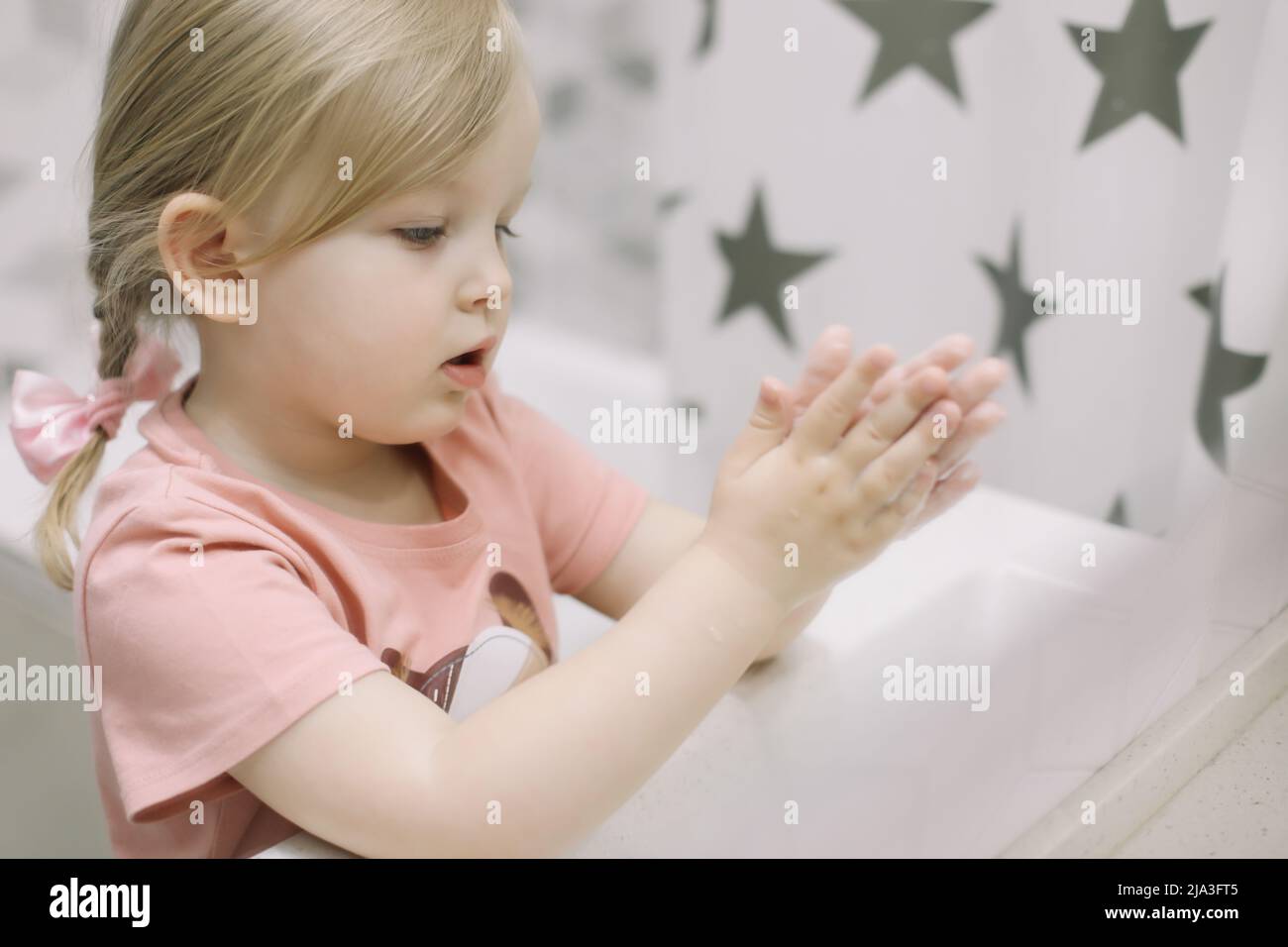Bambina piccola in bagno lavando le mani. Sano, concetto di igiene del bambino. Foto Stock