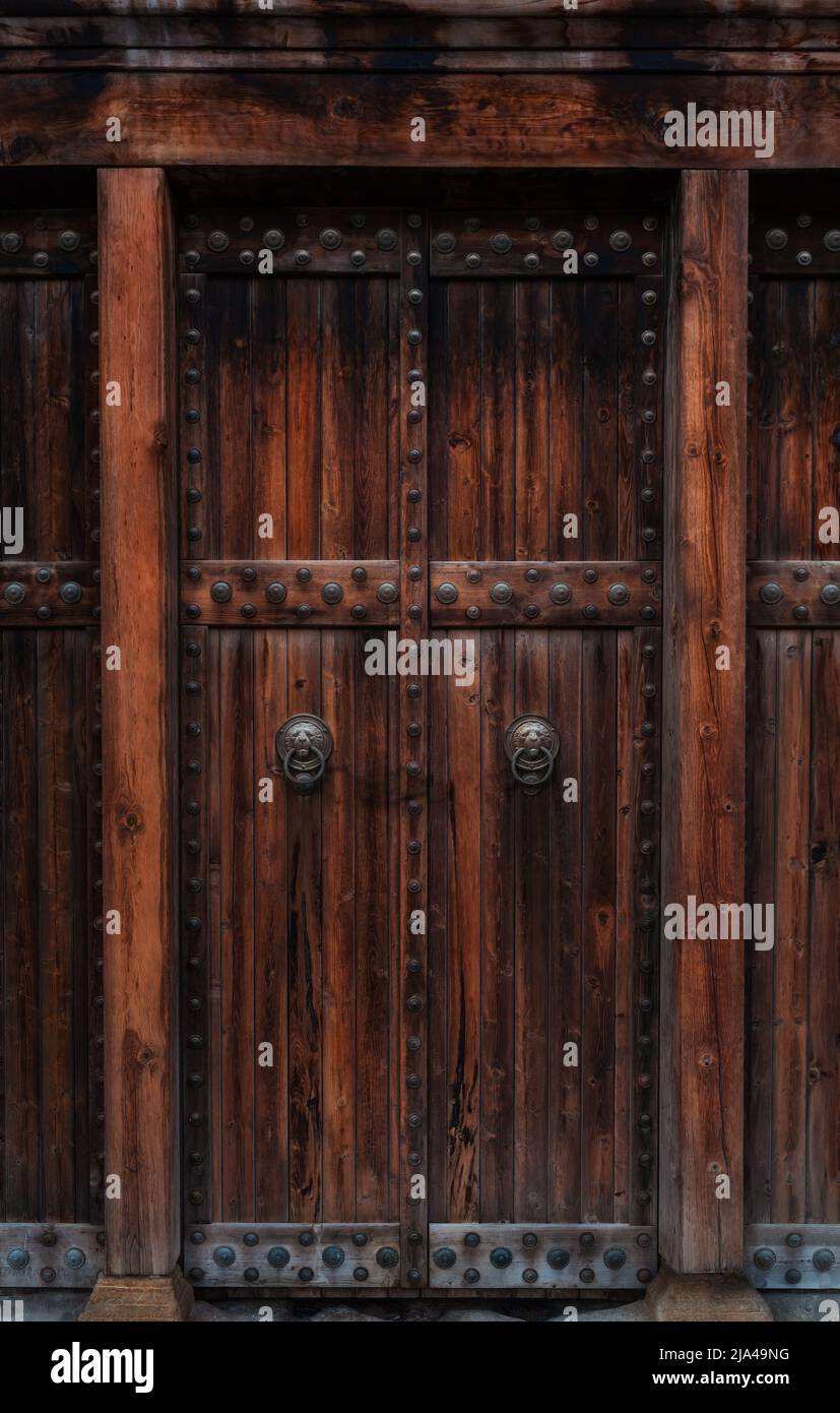 Primo piano di porte in legno scuro con manici e decorazioni in ottone vintage per il tuo design. Stile retrò vintage. Spazio di copia. Sfondo con texture. Foto Stock