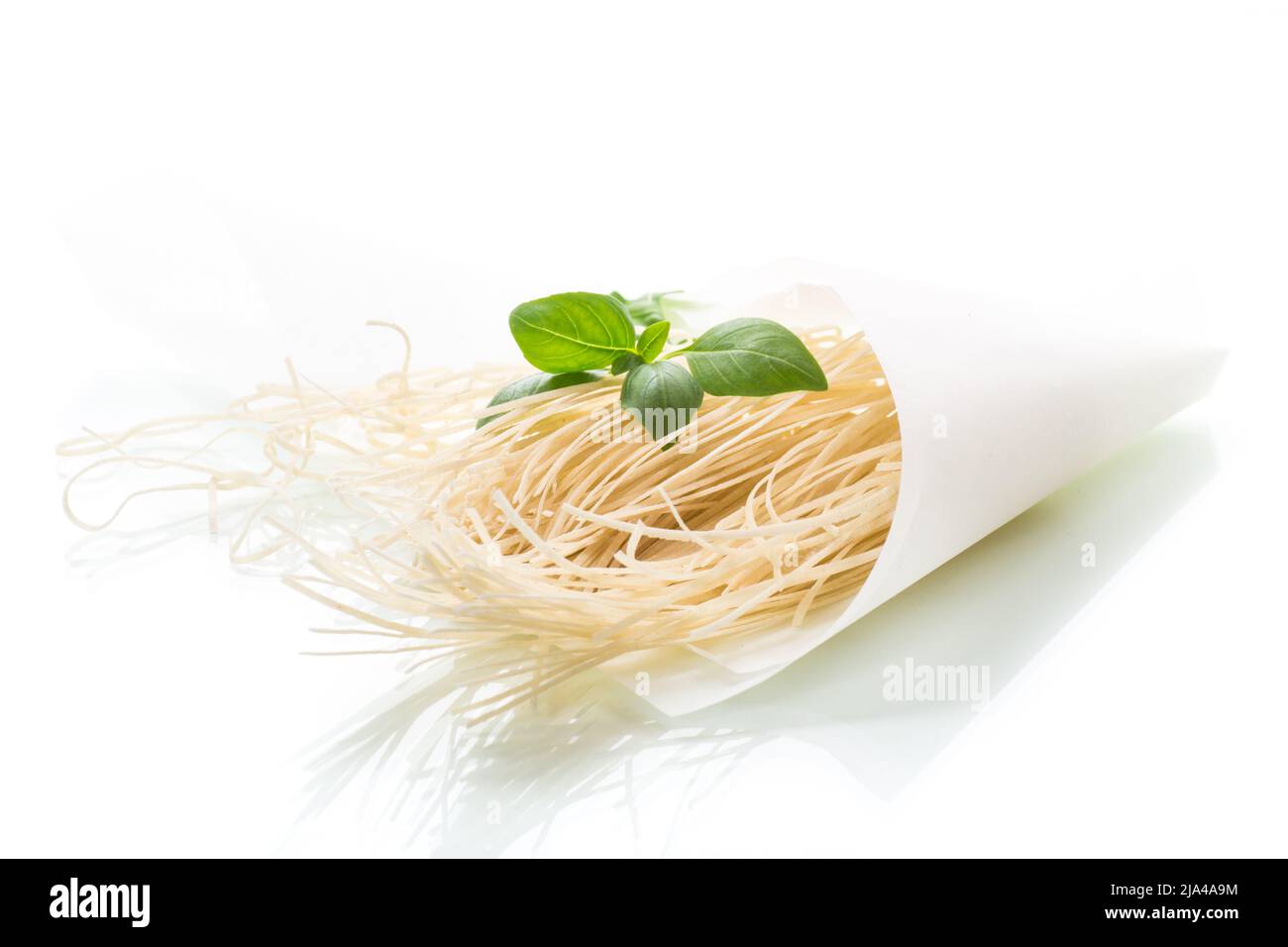 spaghetti fatti in casa secchi in sacchetto di carta con basilico Foto Stock