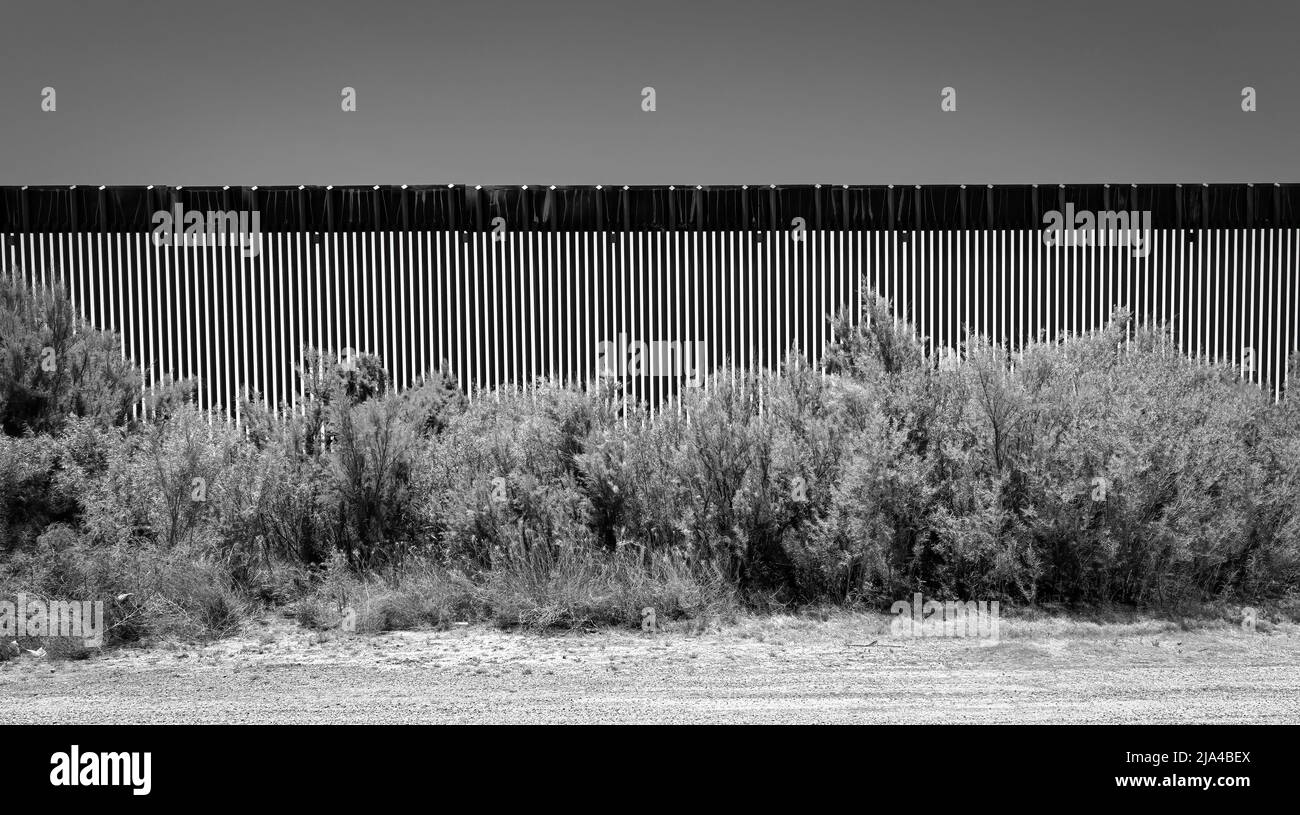 Una strada sterrata corre lungo una sezione del muro di confine tra Stati Uniti e Messico vicino a Fabens, Texas e ad est di El Paso. Foto Stock