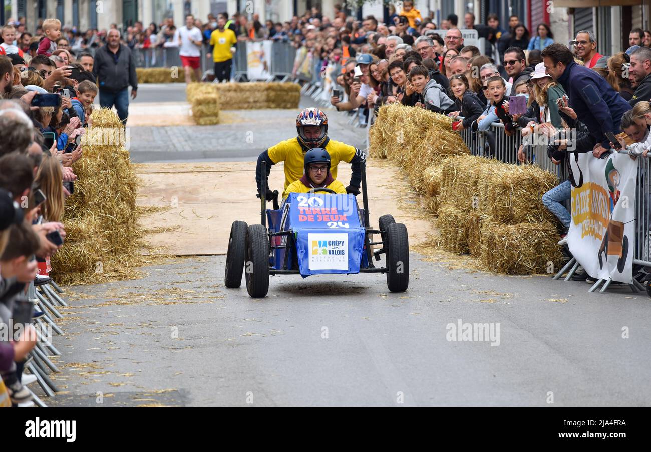 Prima edizione di una gara di soapbox nel cuore del centro della città di Crépy-en-Valois. Una scatola di sapone fatta in casa che precipita lungo il pendio della strada principale. Foto Stock