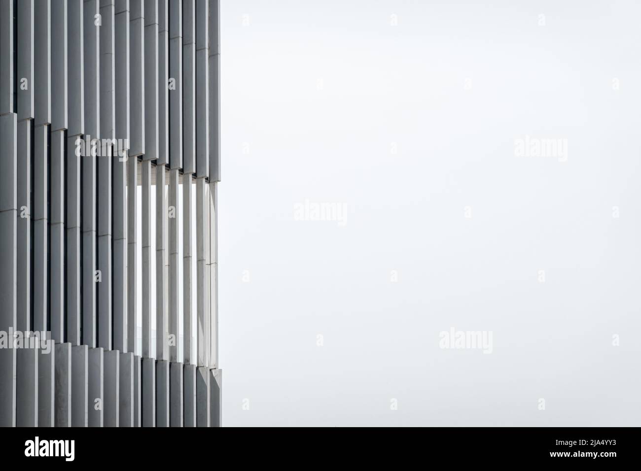 Dettagli in primo piano di colonne in vetro e cemento travi e finestre in architettura moderna edificio per uffici monocromatico facciata bianca grigia a Lisbo Foto Stock