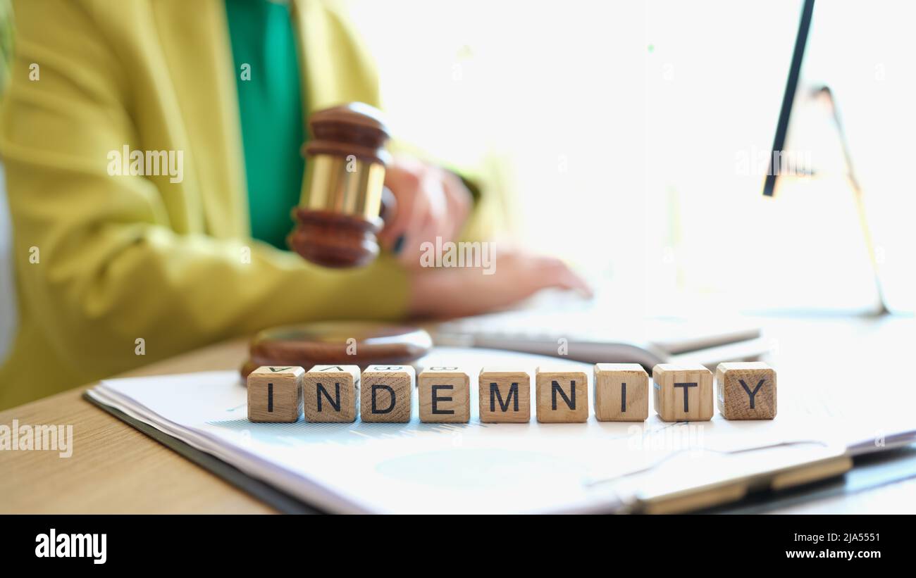 Giudice che tiene il gavel vicino alla parola indemnity closeup Foto Stock