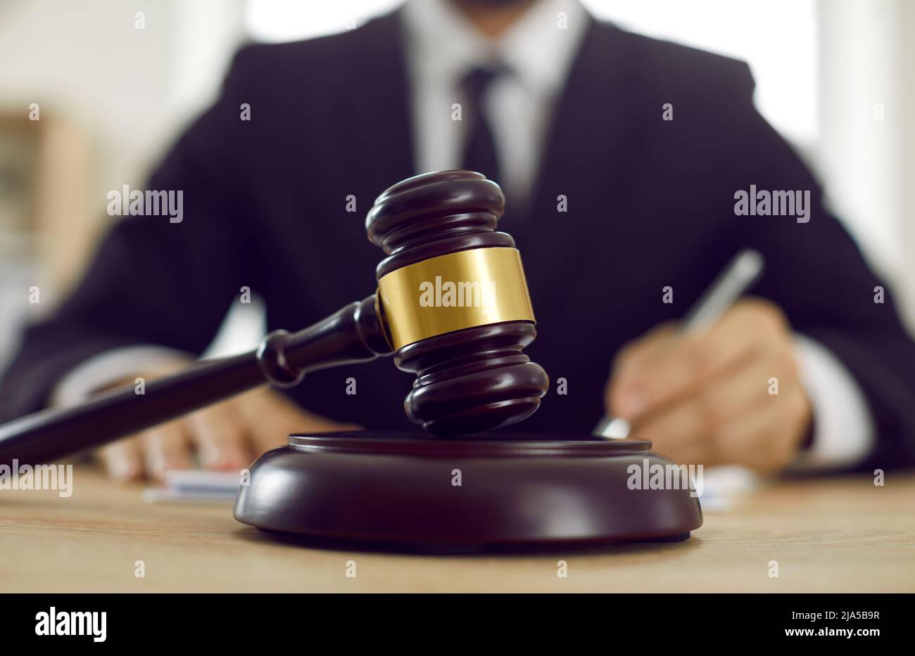 Gavel del giudice e blocco sonoro posto sul tavolo in aula o in ufficio legale Foto Stock
