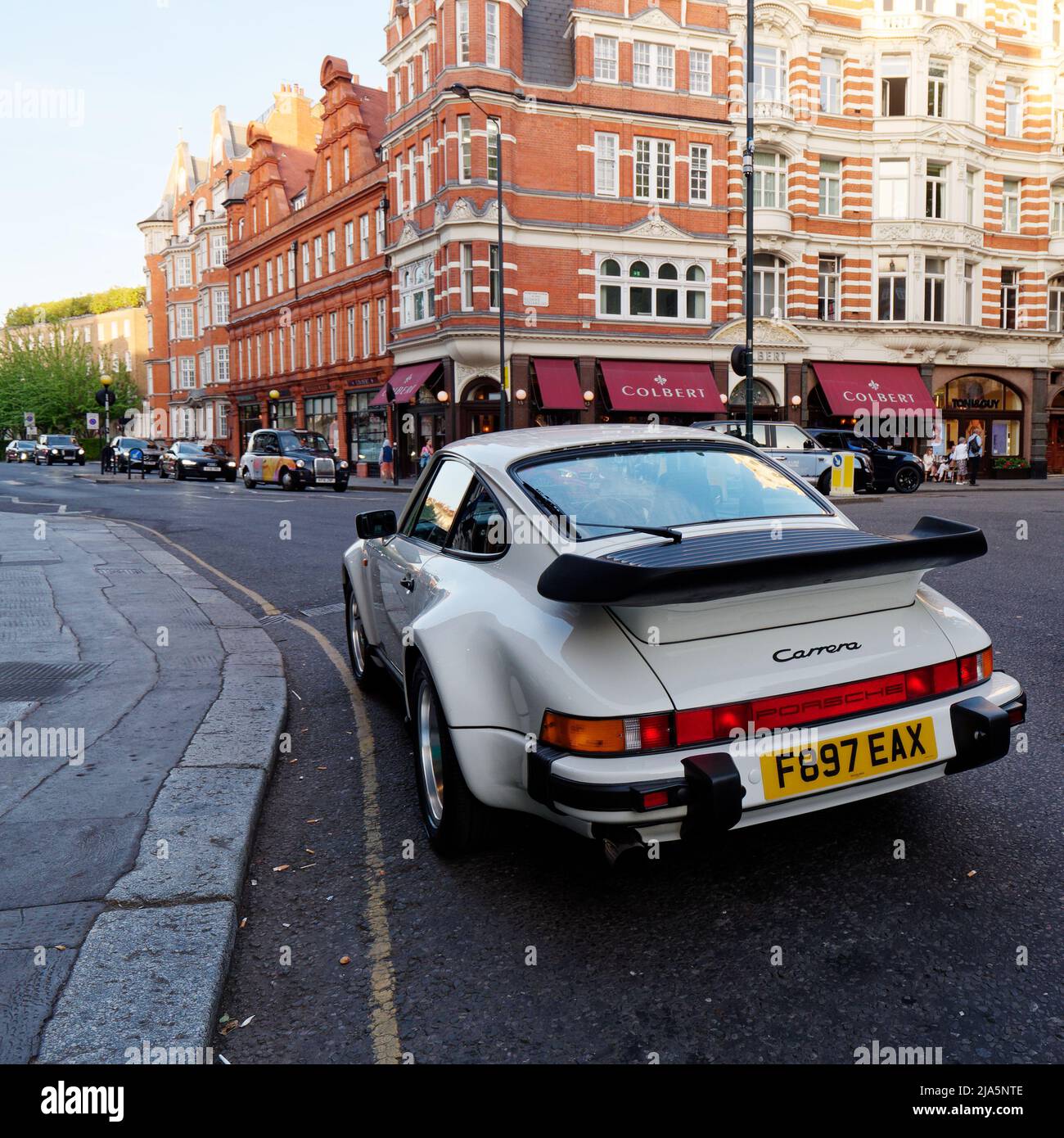 Londra, Greater London, Inghilterra, 14 2022 maggio: Porsche bianca 911 Carrera parcheggiata a Sloane Square Chelsea. Ristorante francese Colbert dietro. Foto Stock