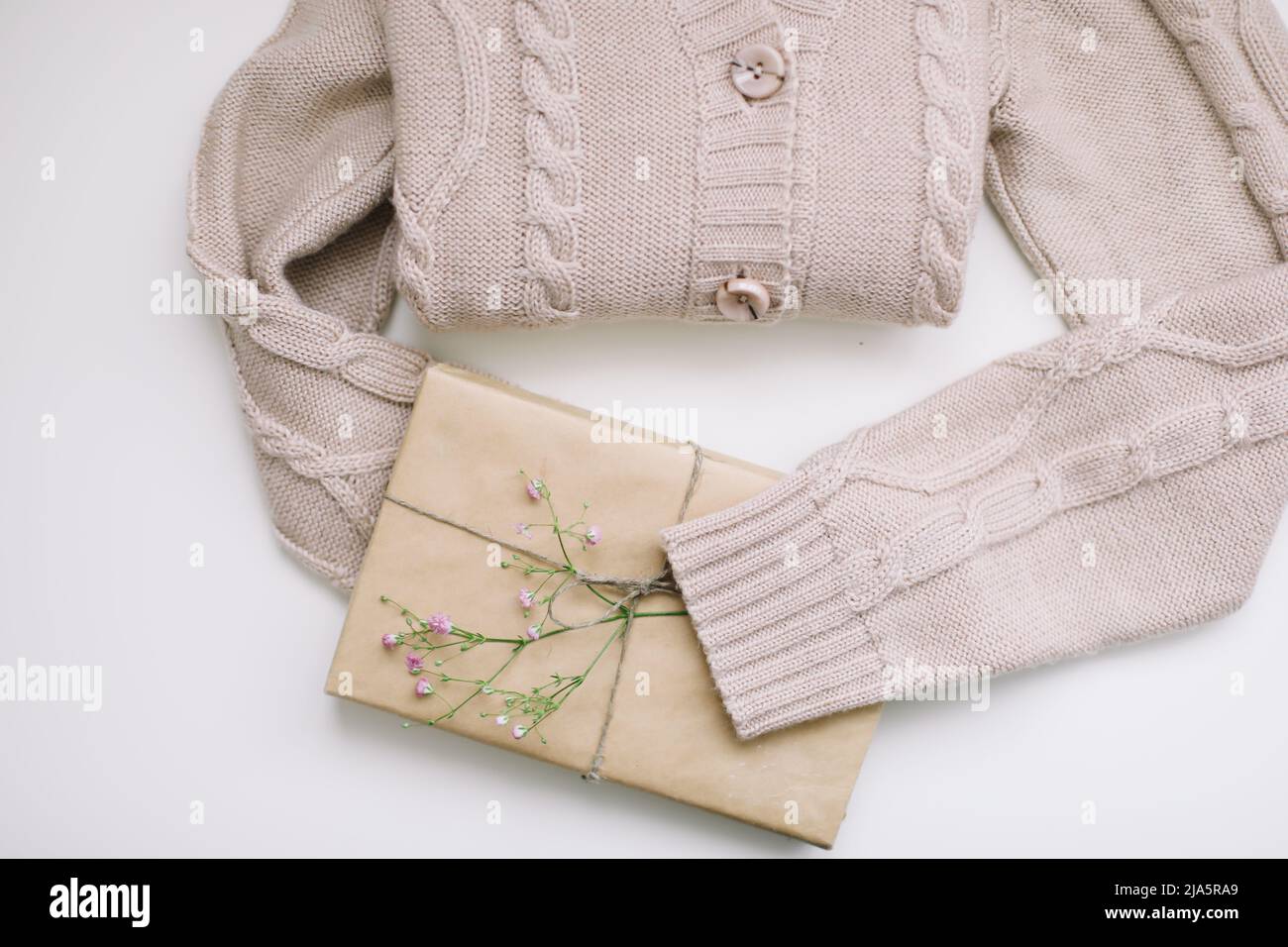 maglia beige maglione e un regalo in carta artigianale, vista dall'alto Foto Stock