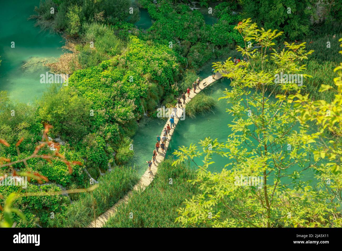 Croazia, Europa - Agosto 2021: Guarda il ponte sul fiume Korana con la gente. Parco Nazionale dei Laghi di Plitvice in Croazia nella regione di Lika. UNESCO Foto Stock