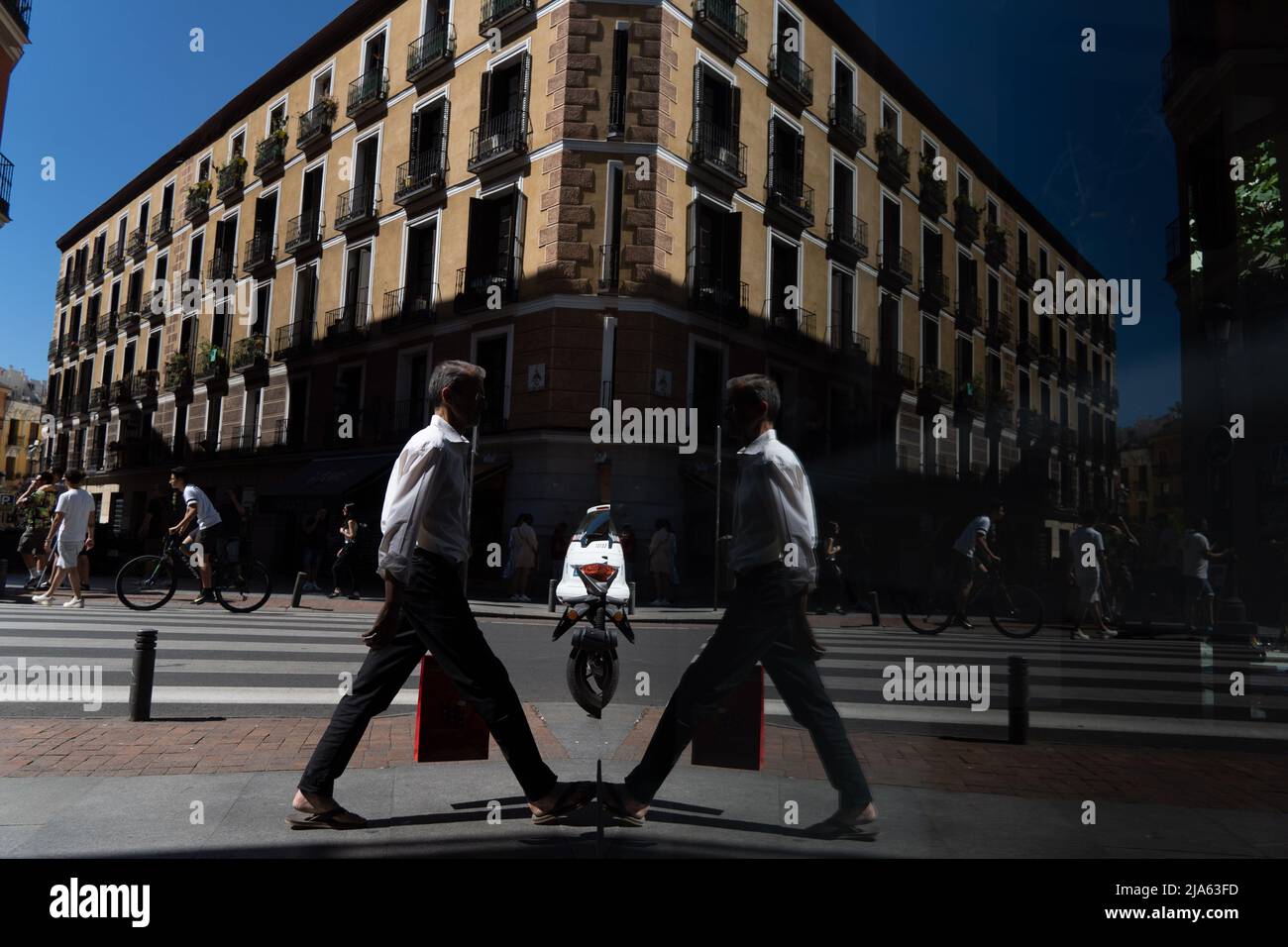 27 maggio 2022, Madrid, Madrid, EspaÃ±a: Un uomo che cammina si riflette nel bicchiere di un negozio a Madrid, Spagna. (Credit Image: © Matias Basualdo/ZUMA Press Wire) Foto Stock