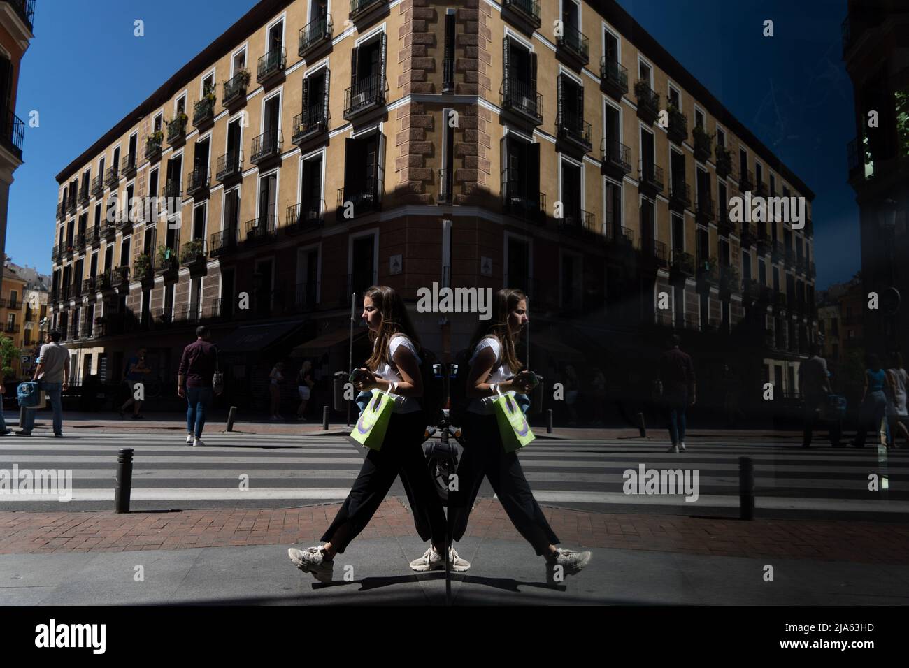 27 maggio 2022, Madrid, Madrid, EspaÃ±a: Una donna che cammina si riflette nel bicchiere di un negozio a Madrid, Spagna. (Credit Image: © Matias Basualdo/ZUMA Press Wire) Foto Stock