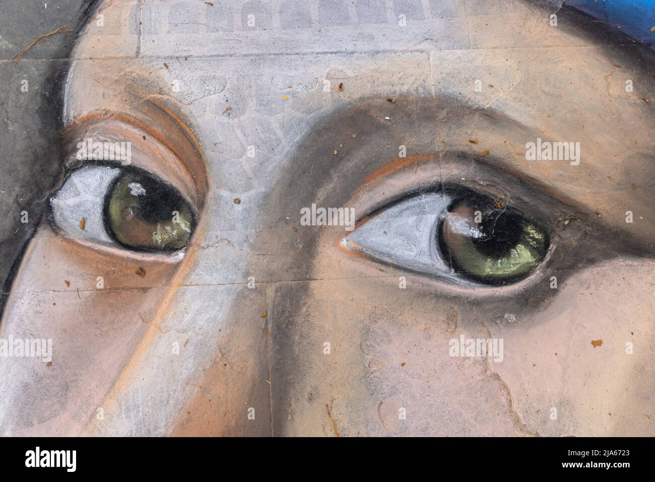 Grado, Italia - 8 luglio 2021: La pittura di Street art della ragazza, occhio marrone profondo e copricapo blu Foto Stock