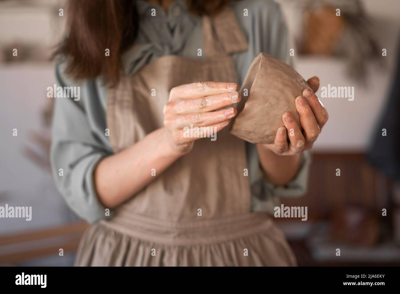 donna vasaio al lavoro. Le mani di Potter in creta formano un vaso in un cerchio, close-up. Femmina che sculpting ciotole da creta bagnata cruda Foto Stock