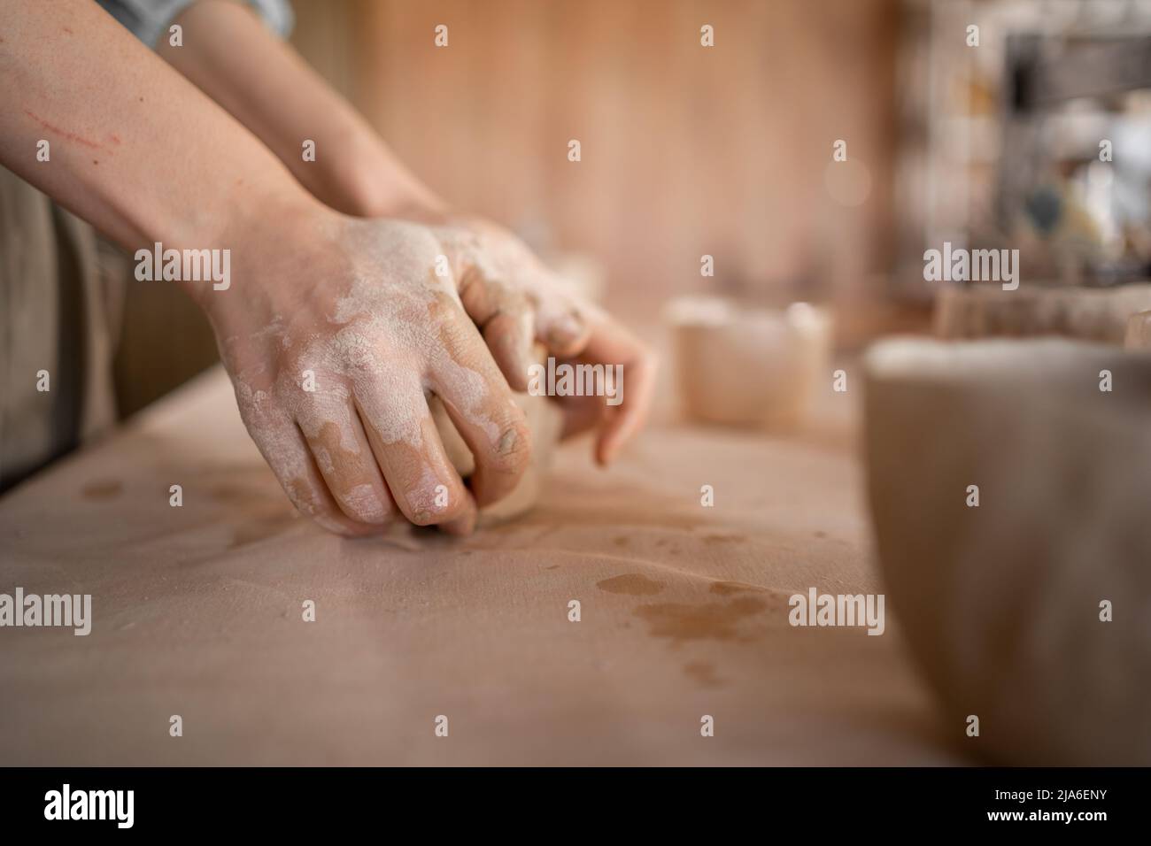 Piccolo lavoro artigianale di ceramica il processo di modellazione e stampaggio di un vaso di argilla in uno studio o workshop. Mano di una donna artigiana. Foto Stock