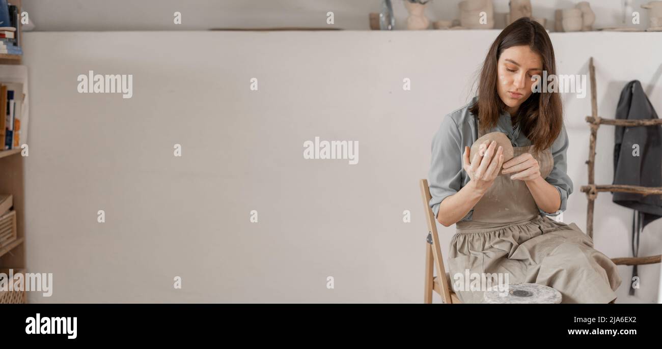 . – artista donna scolpisce da argilla umida in studio. ceramista fa artigianato da ceramica. concetto di industriosità femminile. Foto Stock