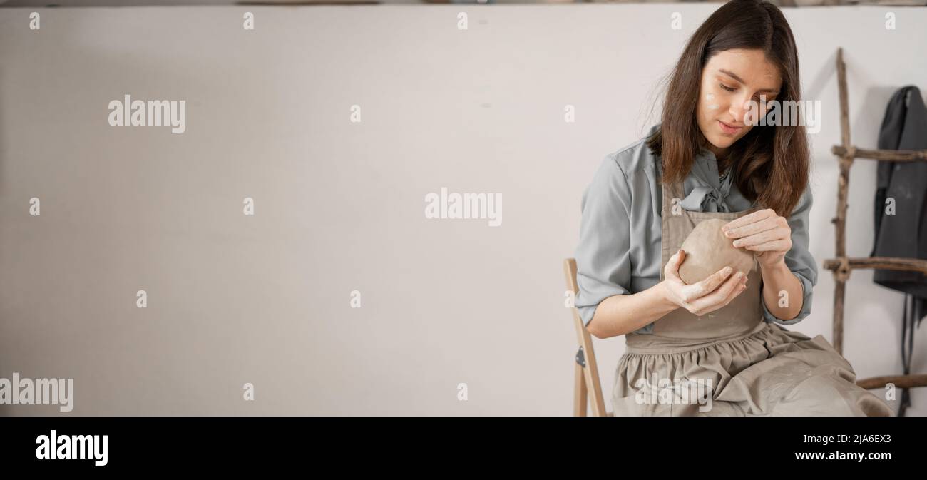 . – artista donna scolpisce da argilla umida in studio. ceramista fa artigianato da ceramica. concetto di industriosità femminile. Foto Stock
